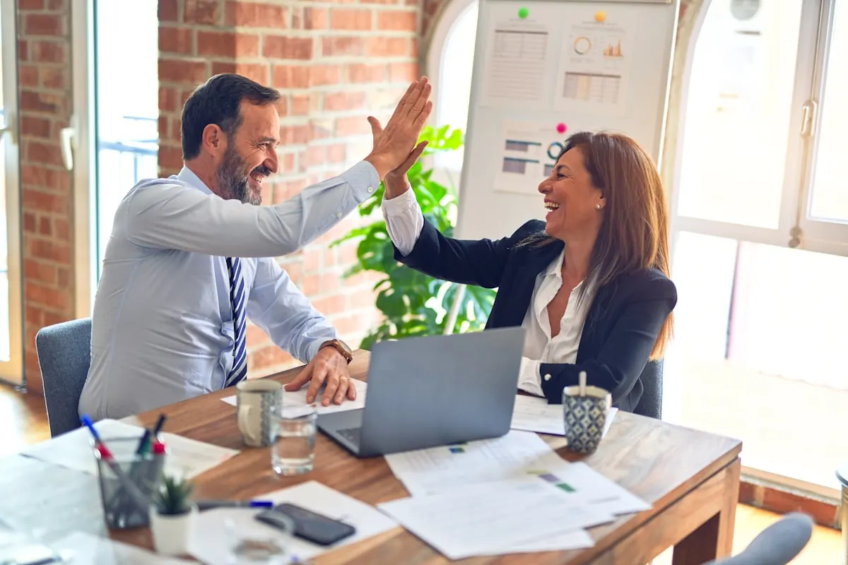 A service business team celebrating a win — the crew energy behind ARKHOS